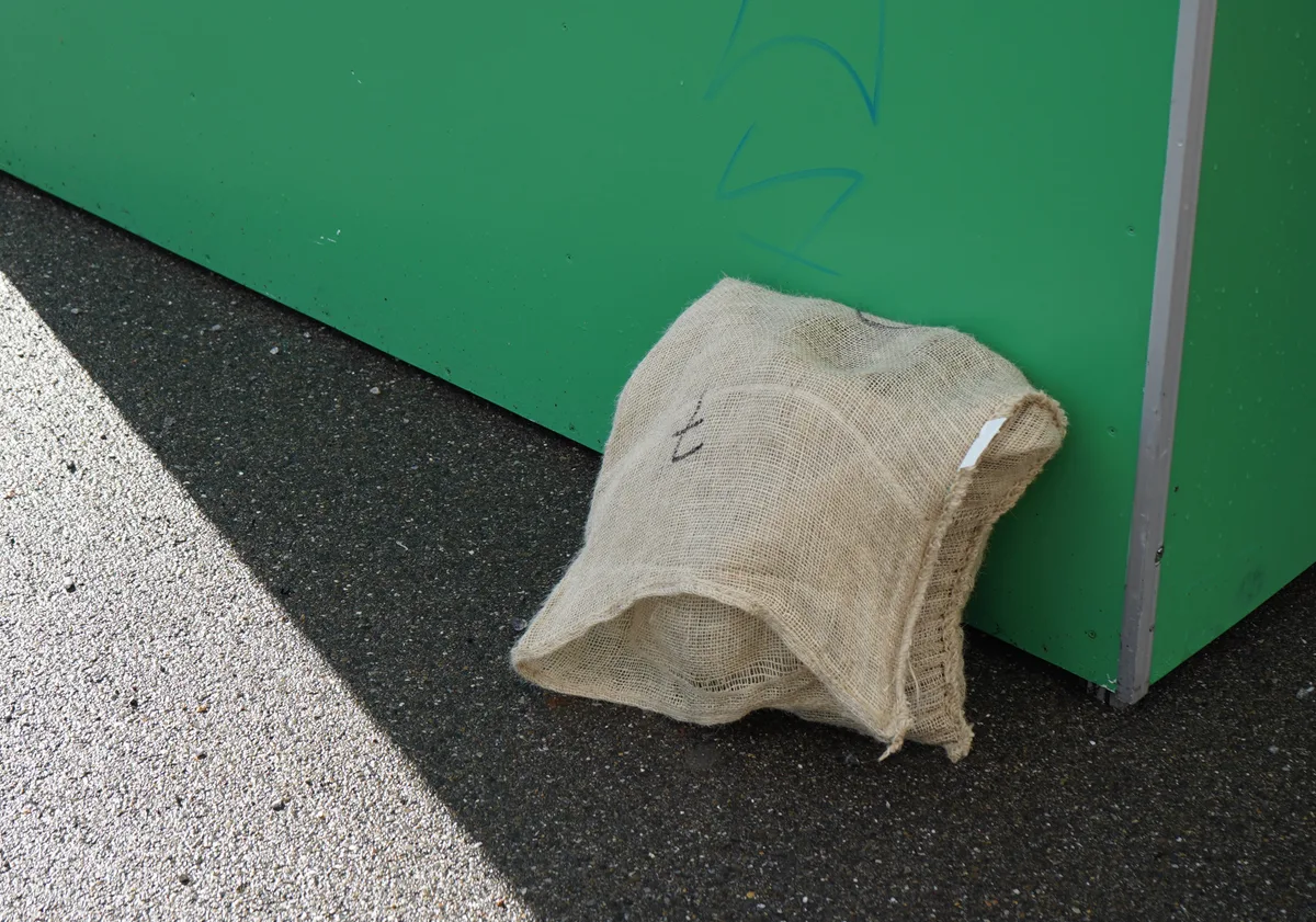 Ein Jutesack voller Marroni steht vor einem Marronistand.